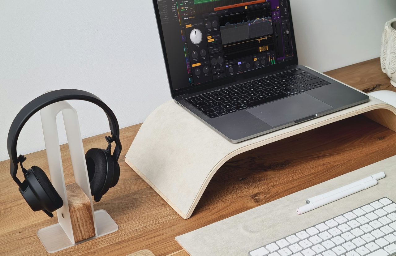 SIMLAF Spectral open on a laptop on an oak desk in daylight, with studio headphones on a stand beside it