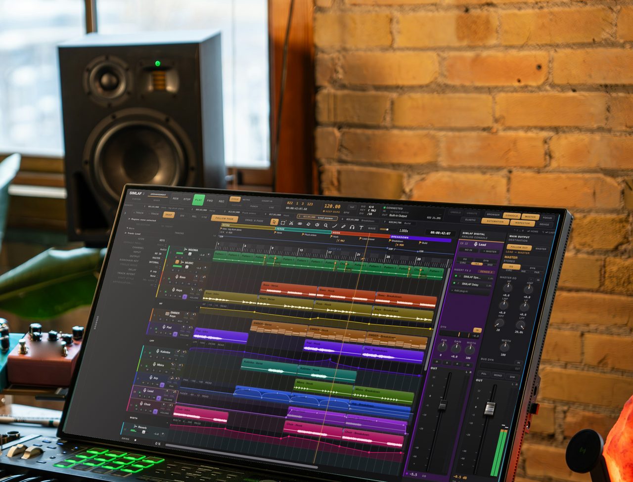 A SIMLAF 2 session on the display of a studio desk by a window: monitor speaker, condenser microphone, guitar pedals and plants in daylight